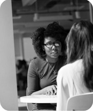 Two people sitting at a table and talking